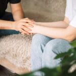 Man and lady hold each other's hands, support for loved one